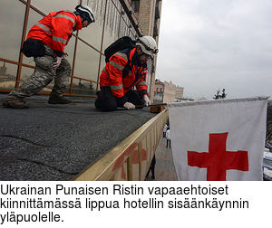 Ukrainan Punaisen Ristin vapaaehtoiset kiinnittmss lippua hotellin sisnkynnin ylpuolelle.
